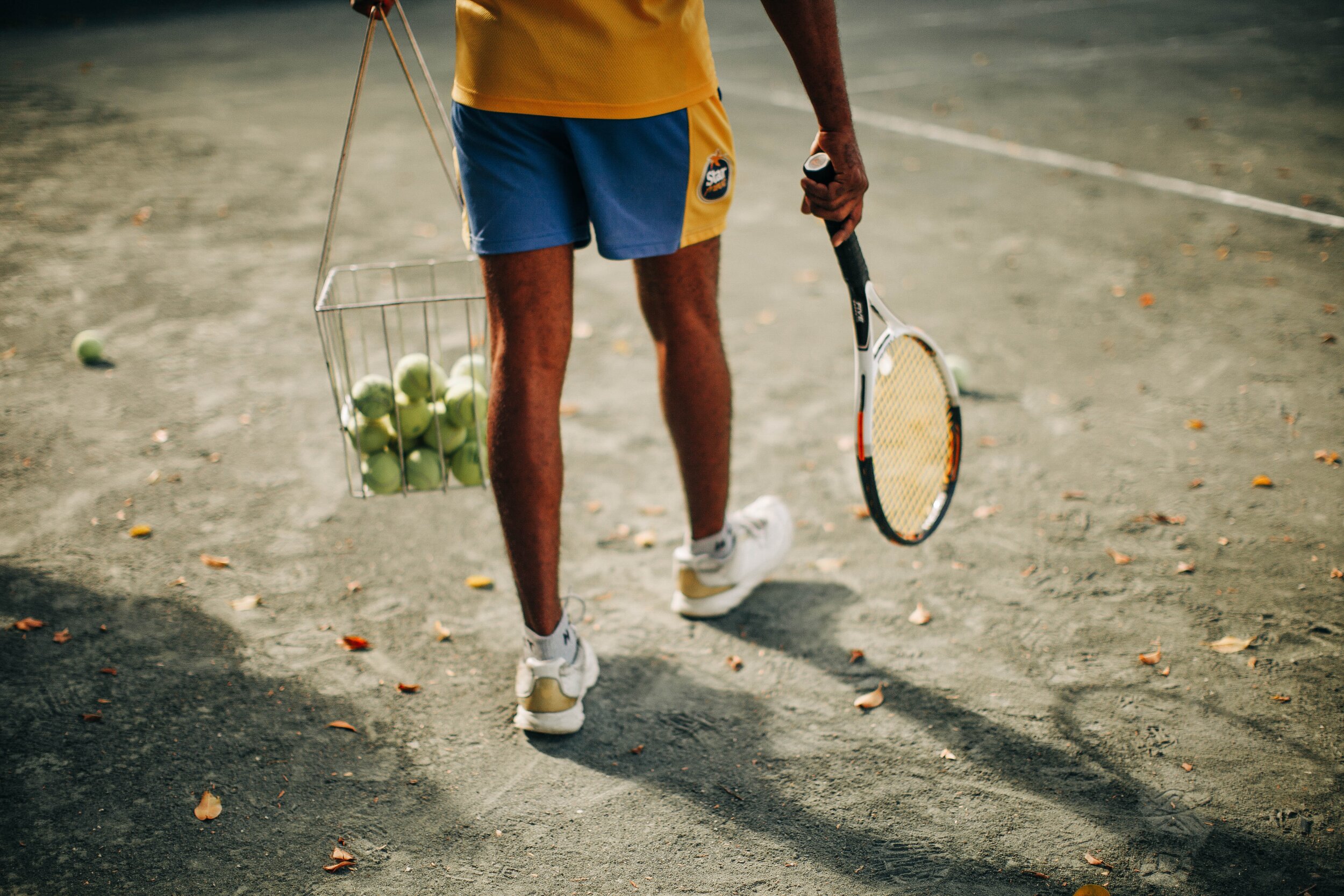 Hombre preparándose para una clase de tenis en una pista al aire libre en Marbella